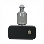 Black magnetic levitation device with a clear glass bulb on a white background